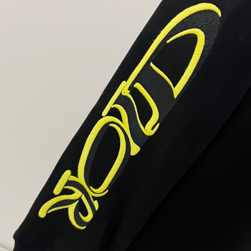 Black sleeve with neon yellow script-style graphic