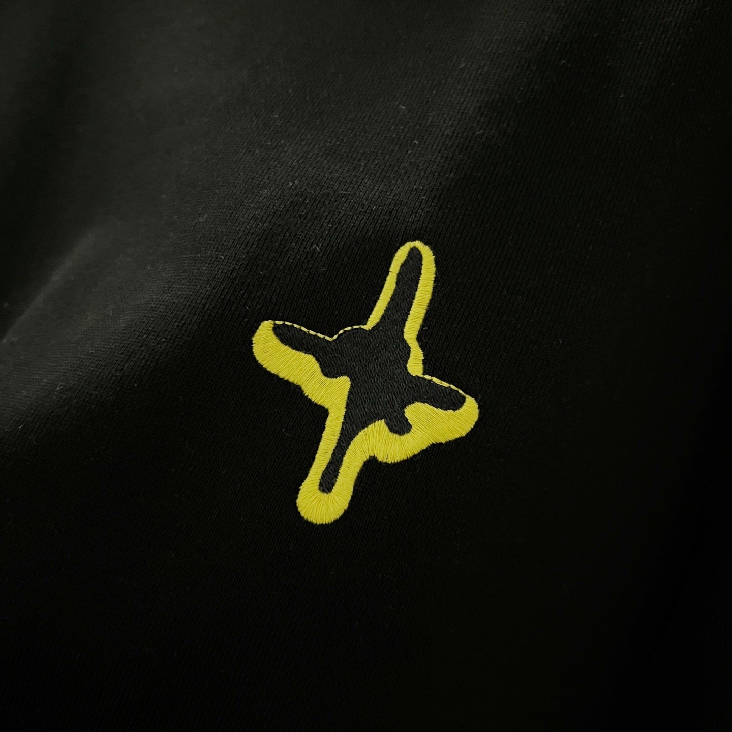 Black fabric with neon yellow star-like cross embroidery