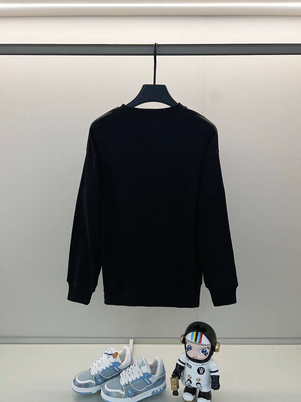 Black long-sleeve shirt on hanger, plain back view