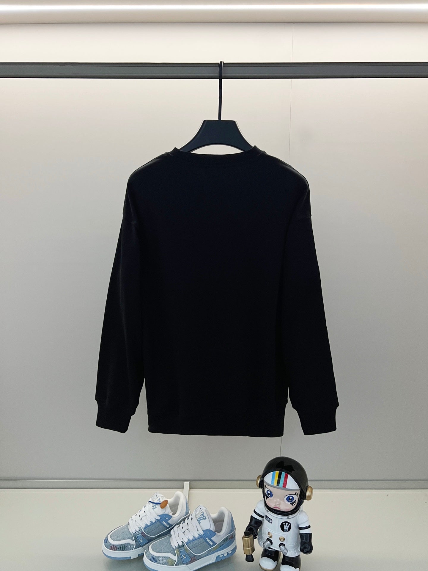 Black long-sleeve shirt on hanger, plain back view