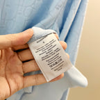 White care label on light blue hoodie interior