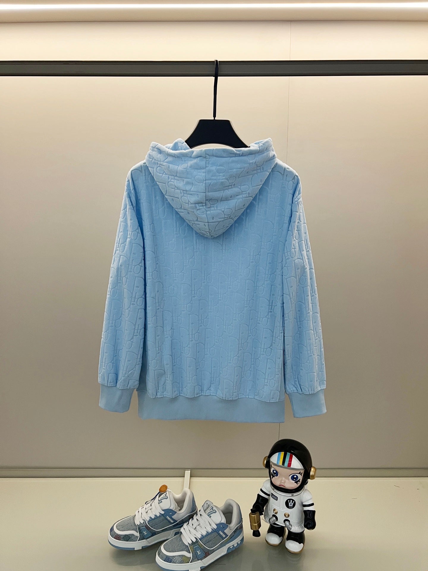 Light blue hoodie with allover logo pattern, drawstring hood, and ribbed cuffs