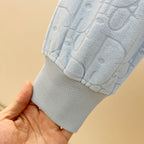 Light blue hoodie sleeve cuff with ribbed hem and raised logo pattern
