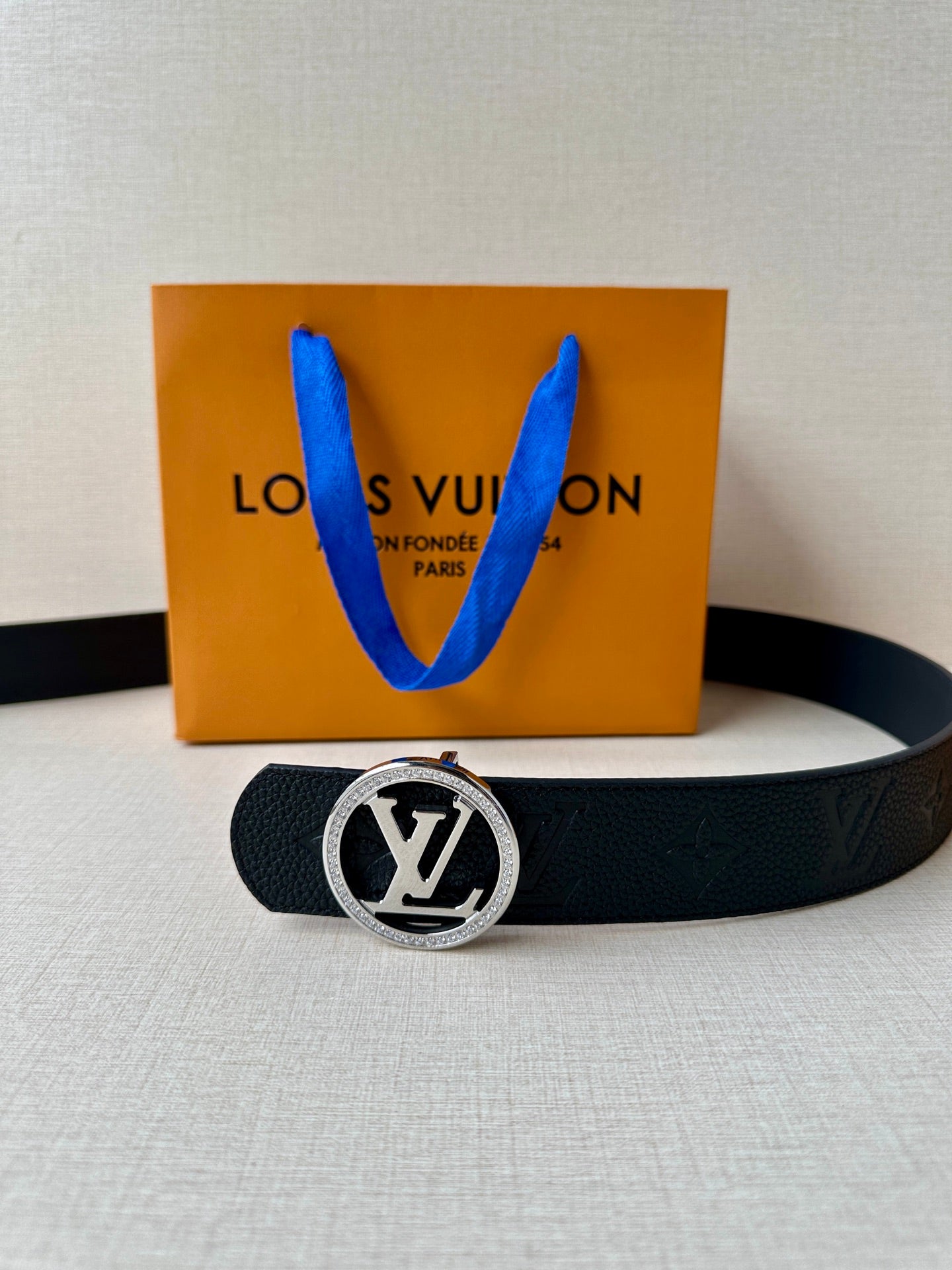 Louis Vuitton dark leather belt with silver logo buckle and embossed monogram pattern