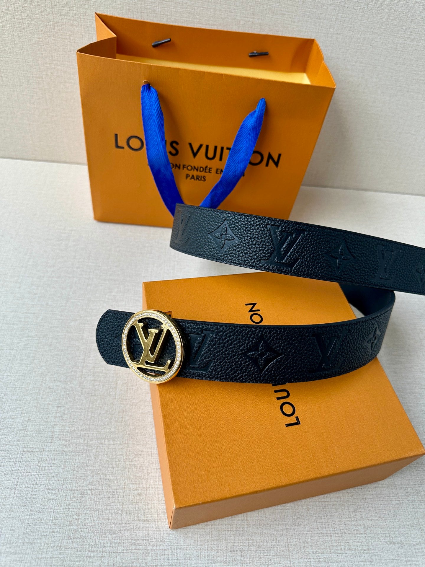 Louis Vuitton dark leather belt with gold logo buckle and embossed monogram pattern