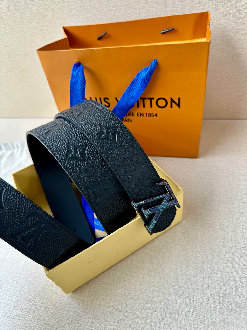 Louis Vuitton belt angled view in dark leather with LV buckle and embossed monogram