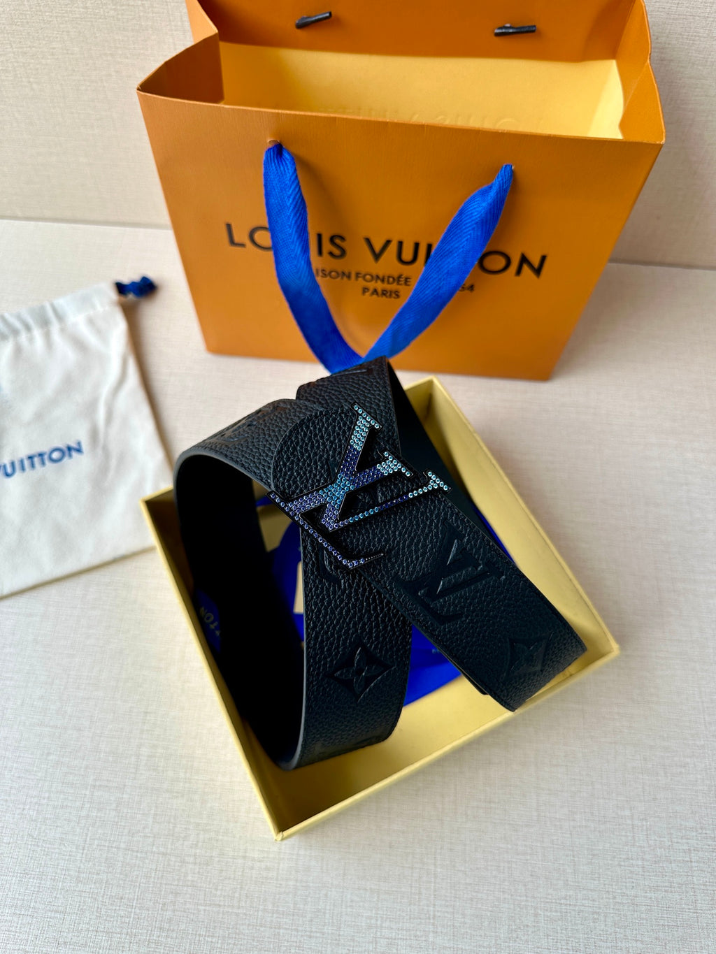 Louis Vuitton belt shown in box: dark monogram leather strap with LV buckle
