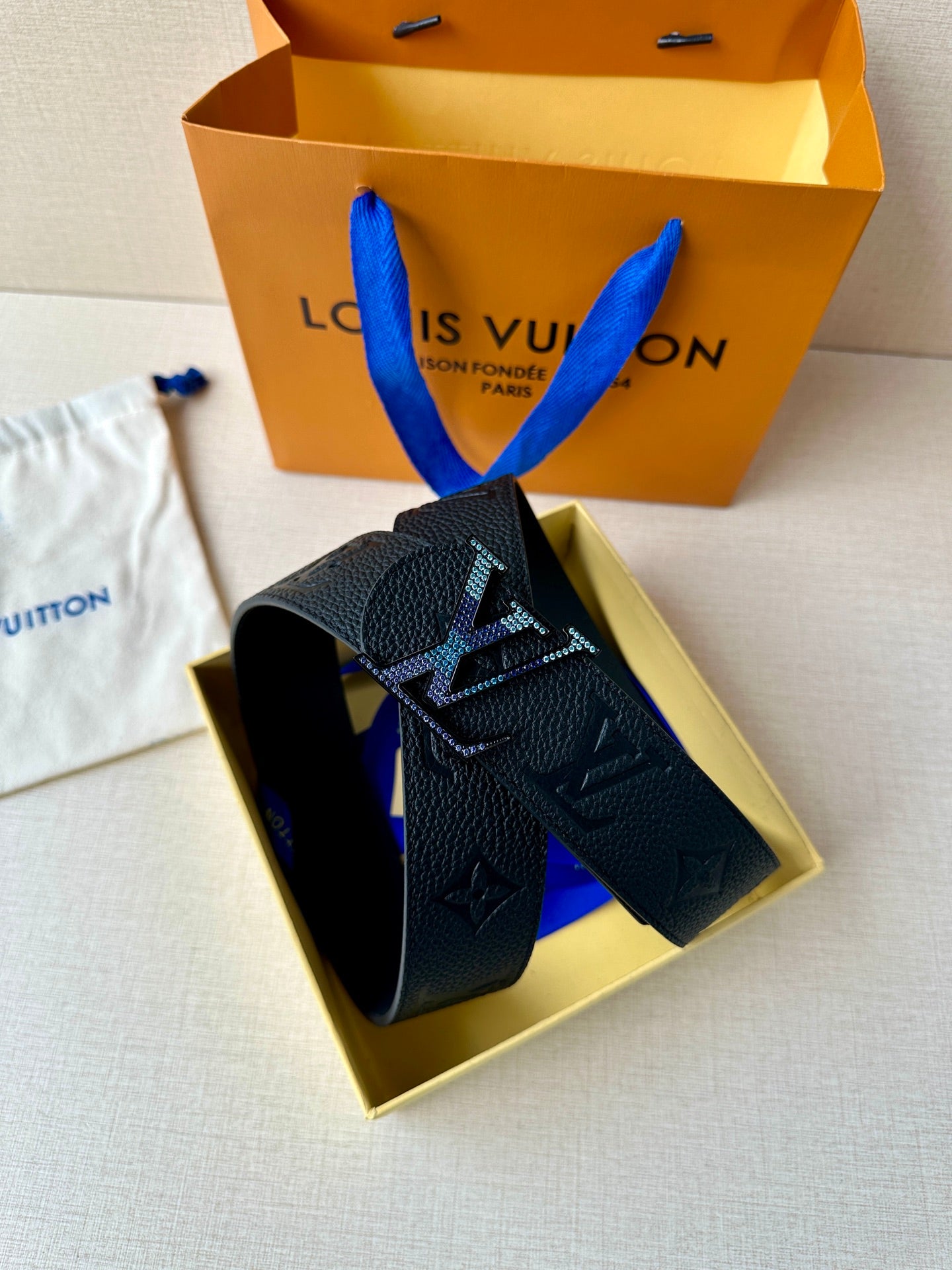 Louis Vuitton belt shown in box: dark monogram leather strap with LV buckle