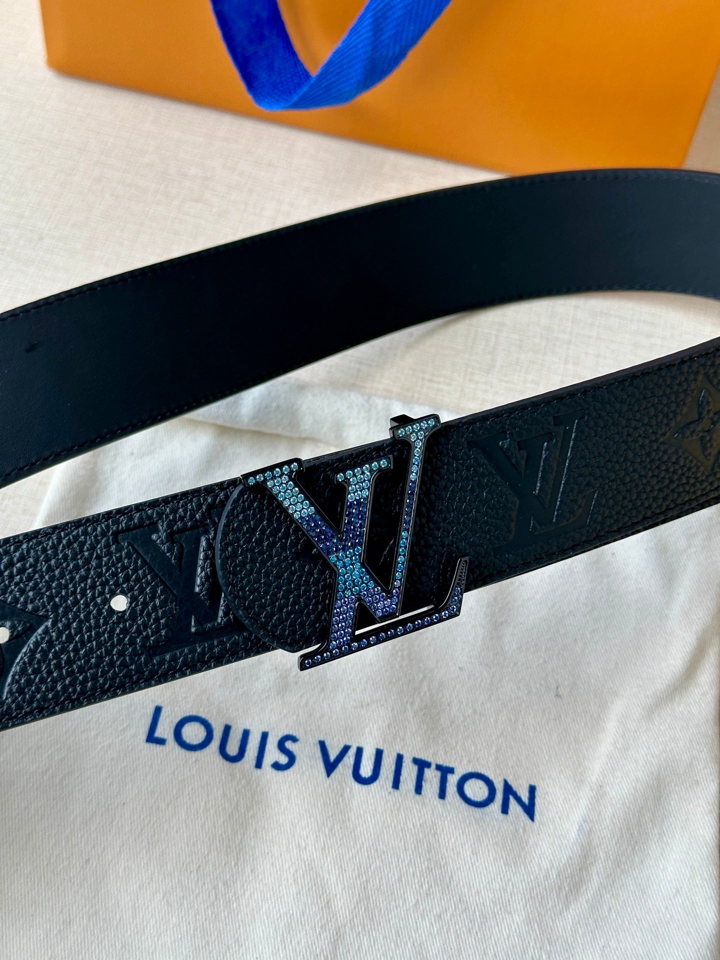 Louis Vuitton belt close-up: dark patterned leather strap with LV square buckle