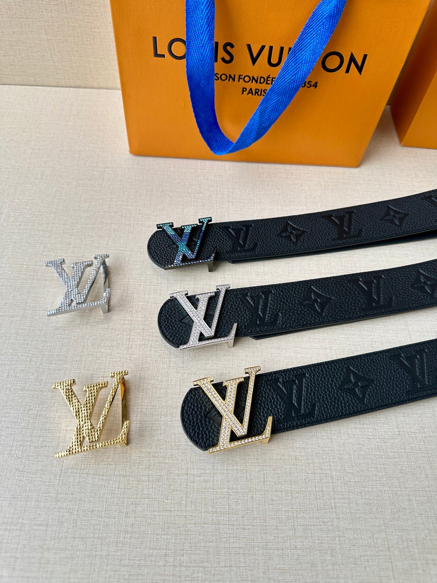 Louis Vuitton belt with multiple LV buckle styles and dark monogram strap