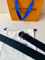 Louis Vuitton belt laid on pouch: dark leather strap with LV buckle and monogram