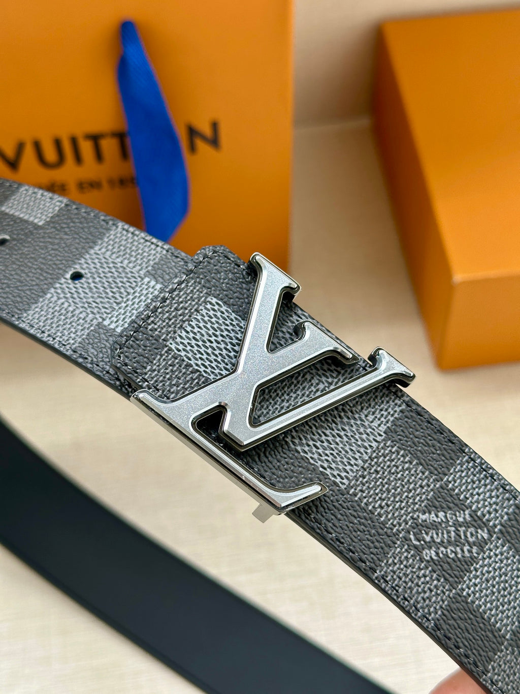 Dark gray check belt strap with silver LV buckle and metal pin holes