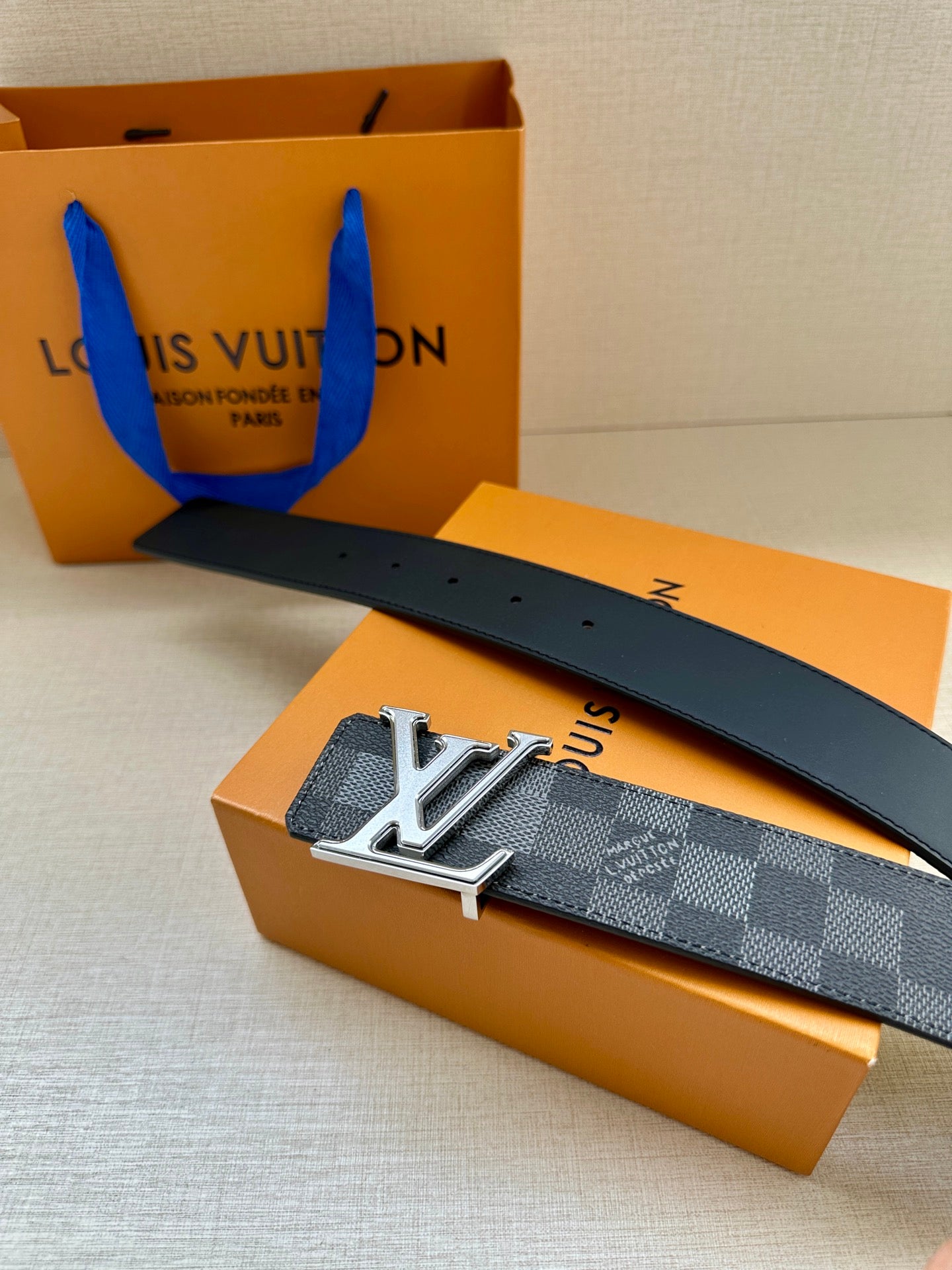 Dark gray check belt with silver LV buckle and dark leather belt strap