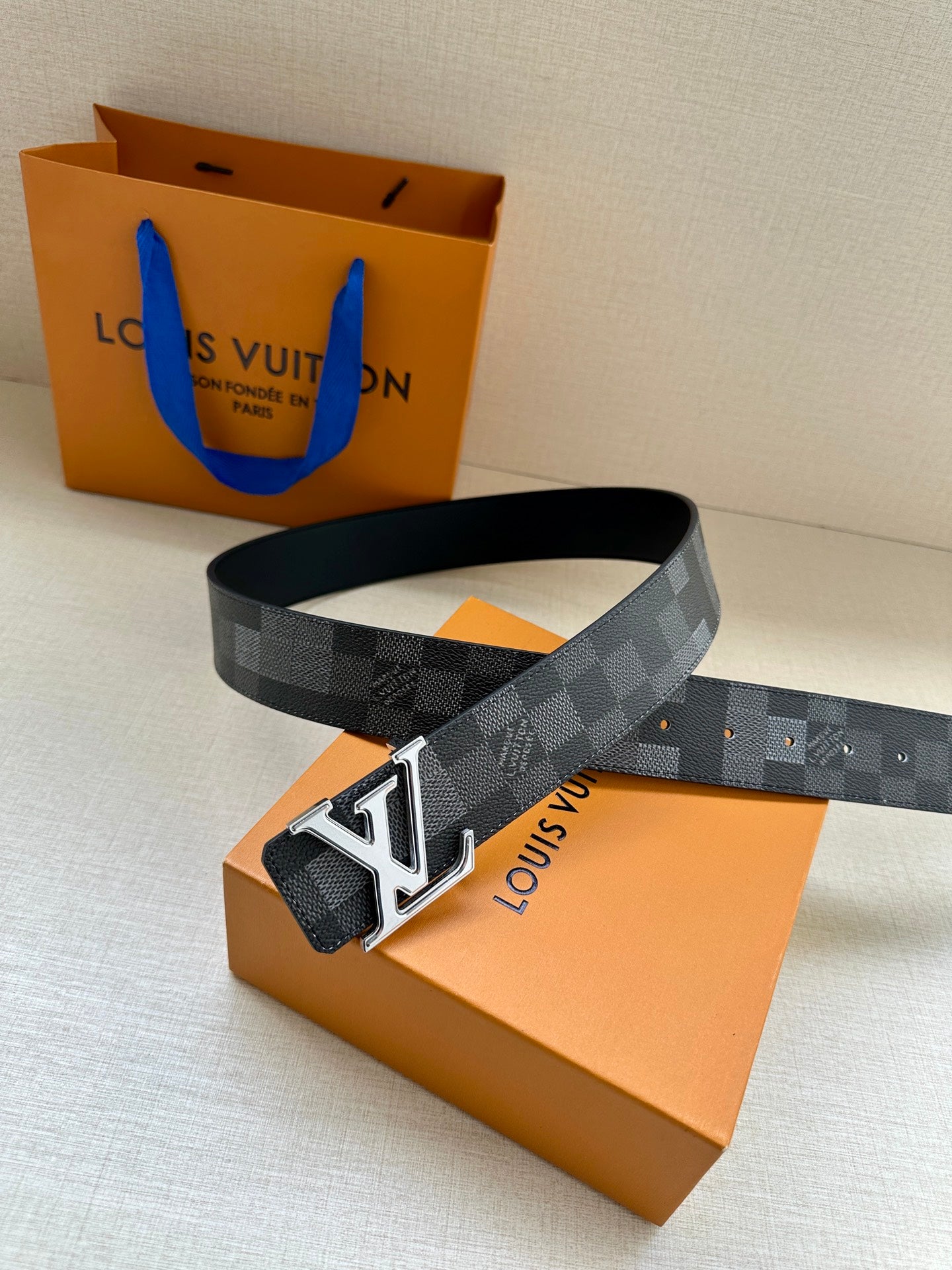 Dark gray check belt with silver LV buckle and stitched leather keeper