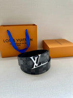 Dark gray check belt with oversized silver LV buckle and adjustable holes