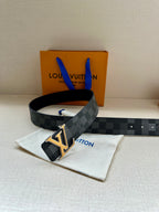 Louis Vuitton Damier belt with gold LV buckle on dark strap, laid on pouch