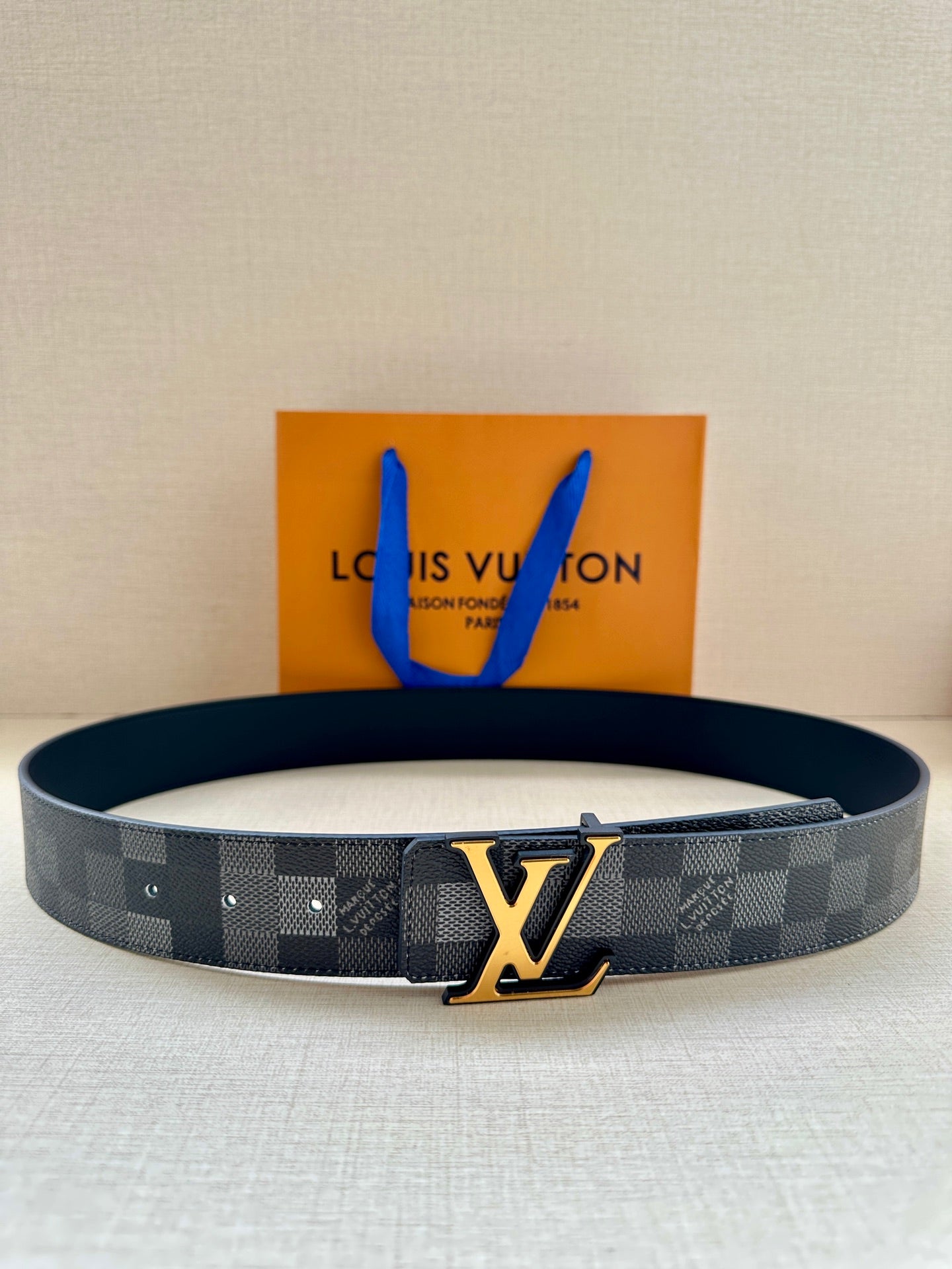 Louis Vuitton Damier patterned belt with gold LV buckle, dark gray/black strap