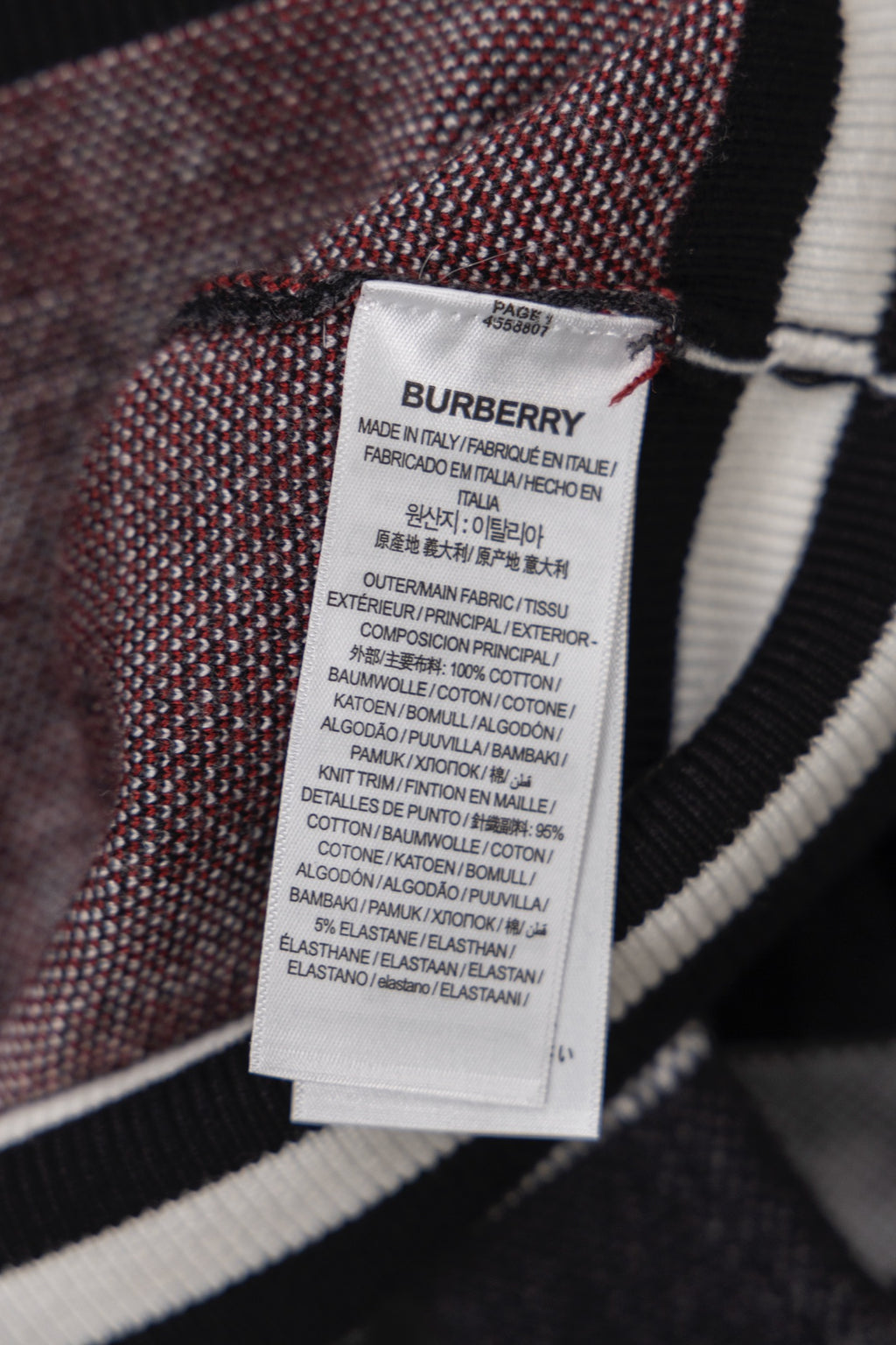 Inside care label tag on plaid zip cardigan, white label with printed text