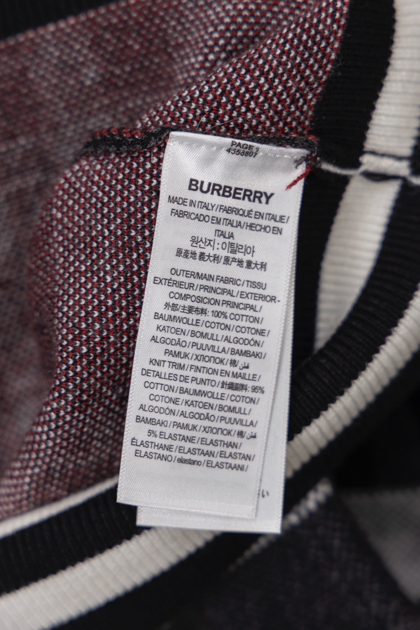 Inside care label tag on plaid zip cardigan, white label with printed text