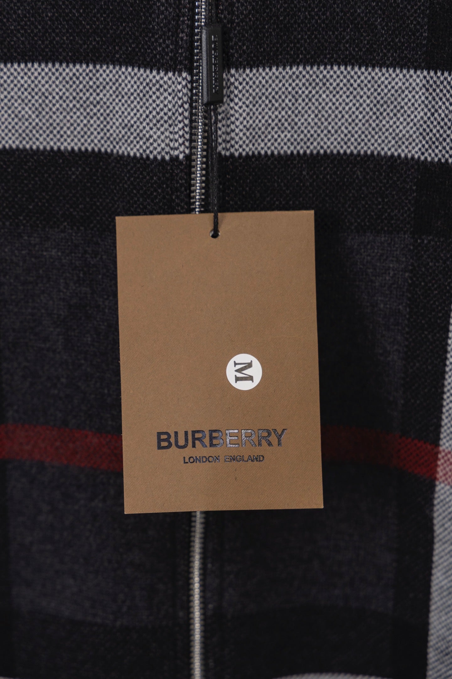 Burberry logo hang tag on plaid zip cardigan front