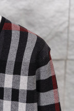 Plaid cardigan sleeve with bold white stripes over dark and red check pattern