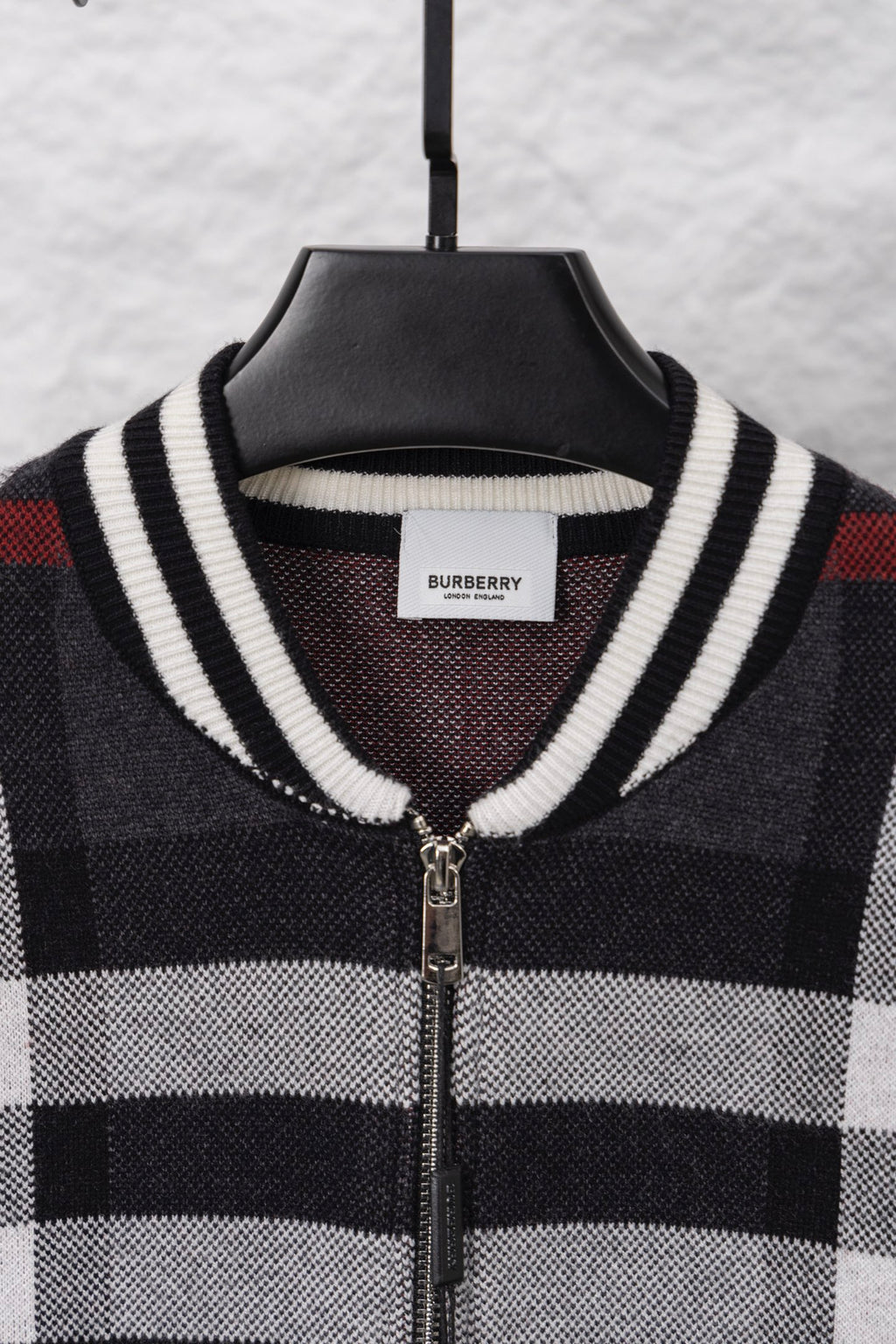 Plaid zip cardigan neckline with ribbed striped trim and front zipper, dark with white/red