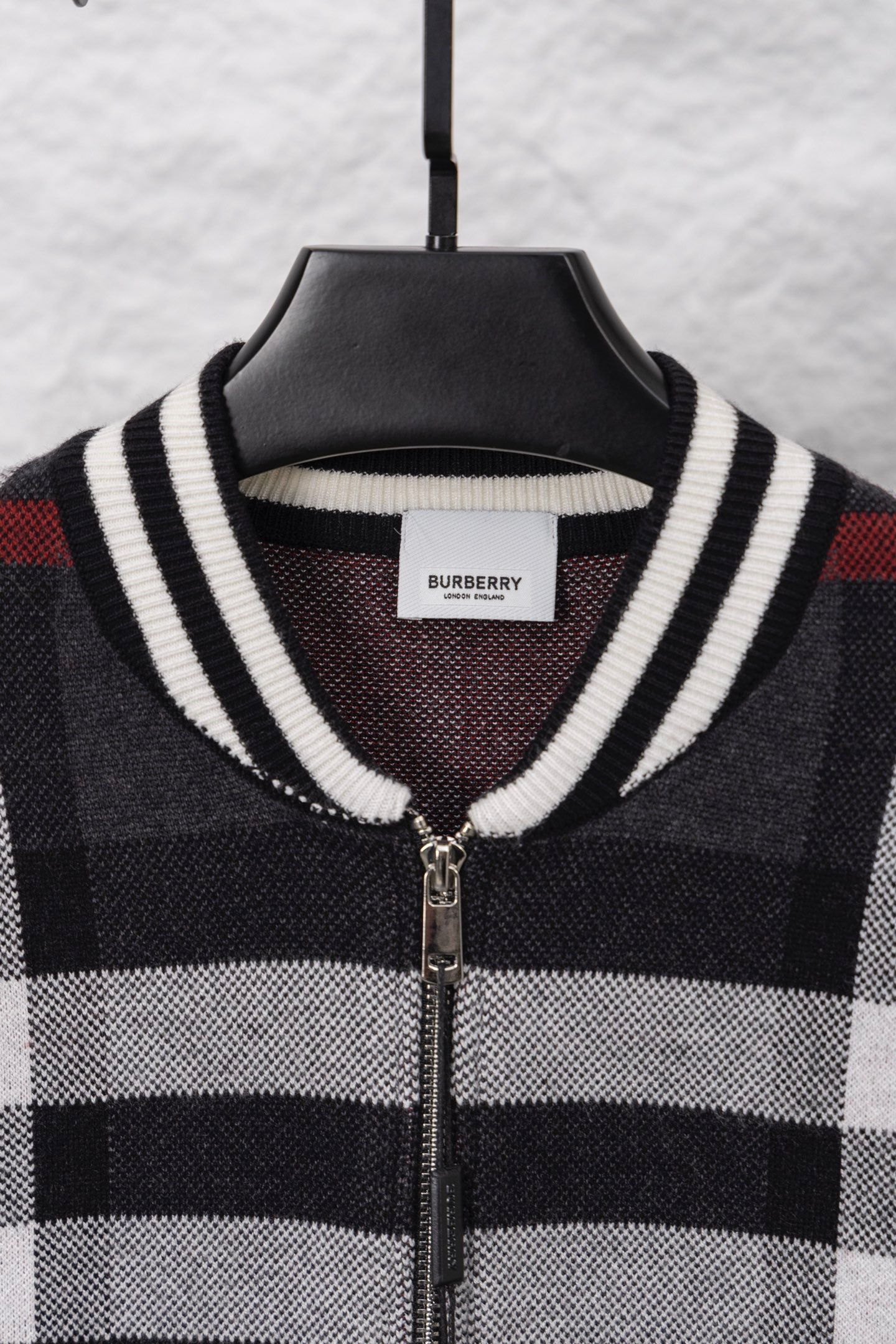 Plaid zip cardigan neckline with ribbed striped trim and front zipper, dark with white/red