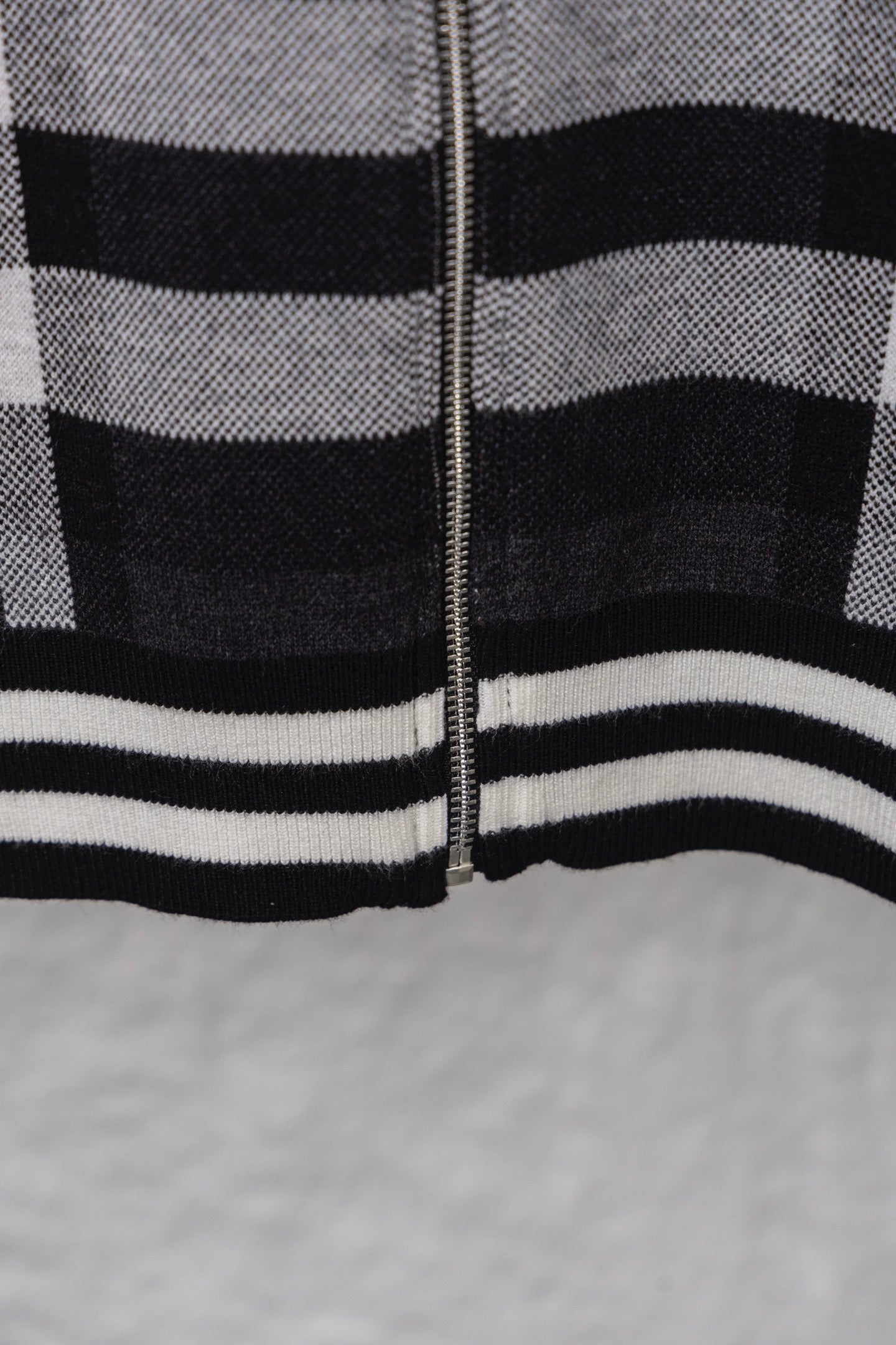 Plaid zip cardigan lower front with ribbed stripes and zipper, dark with white and red blocks