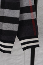 Plaid cardigan sleeve cuff with ribbed black-and-white stripes, dark with red check