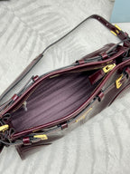 Prada burgundy leather bag open view with interior lining and gold hardware frame