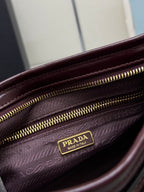Prada burgundy leather bag interior close-up with zip closure and logo label on lining