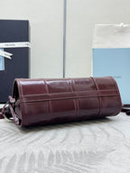 Prada burgundy leather cylindrical mini bag with stitched panels and gold trim hardware