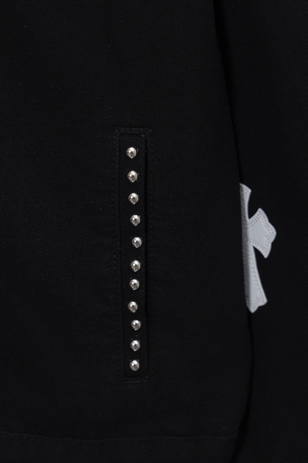 Black shirt front placket detail with vertical row of silver studs