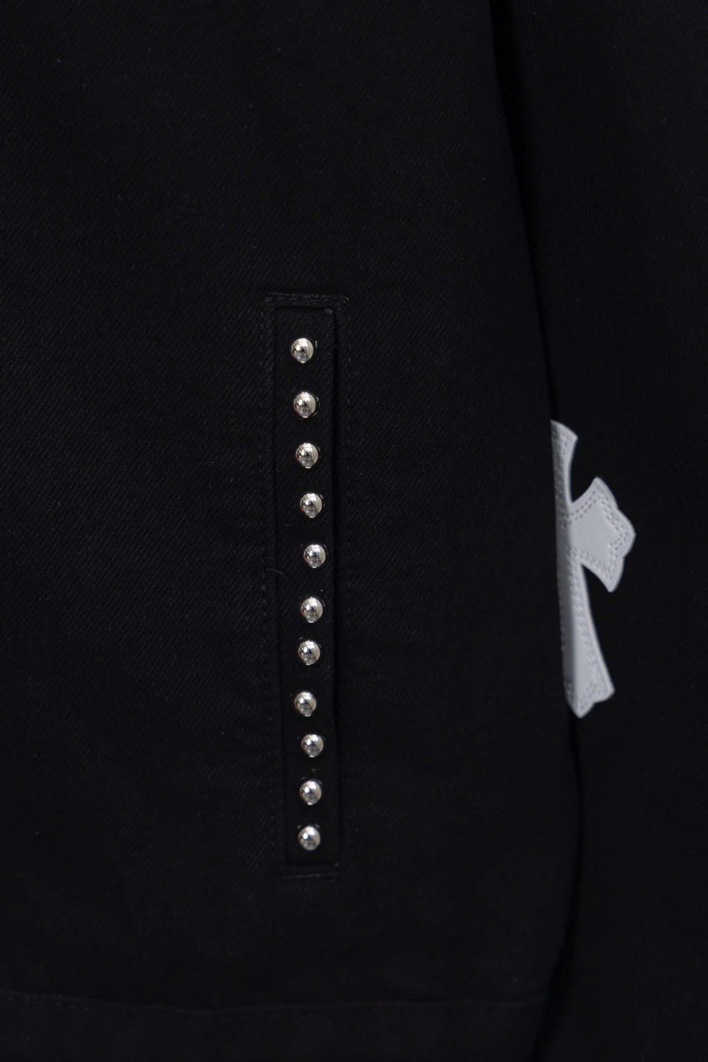 Black shirt front placket detail with vertical row of silver studs