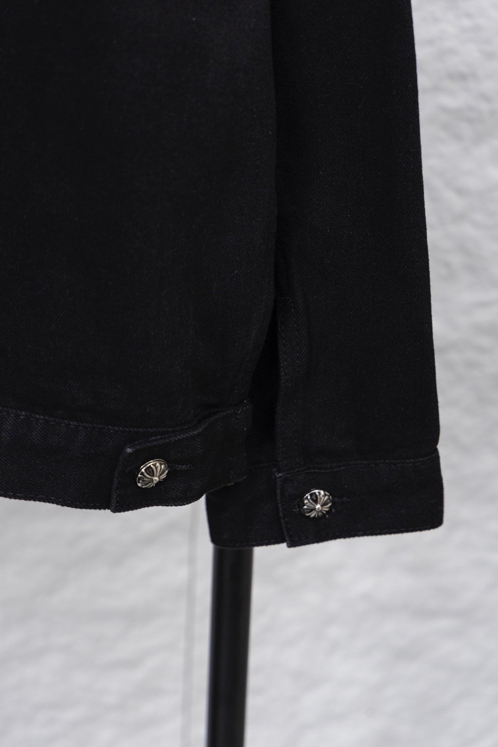 Black denim shirt sleeve cuff with round emblem snap button