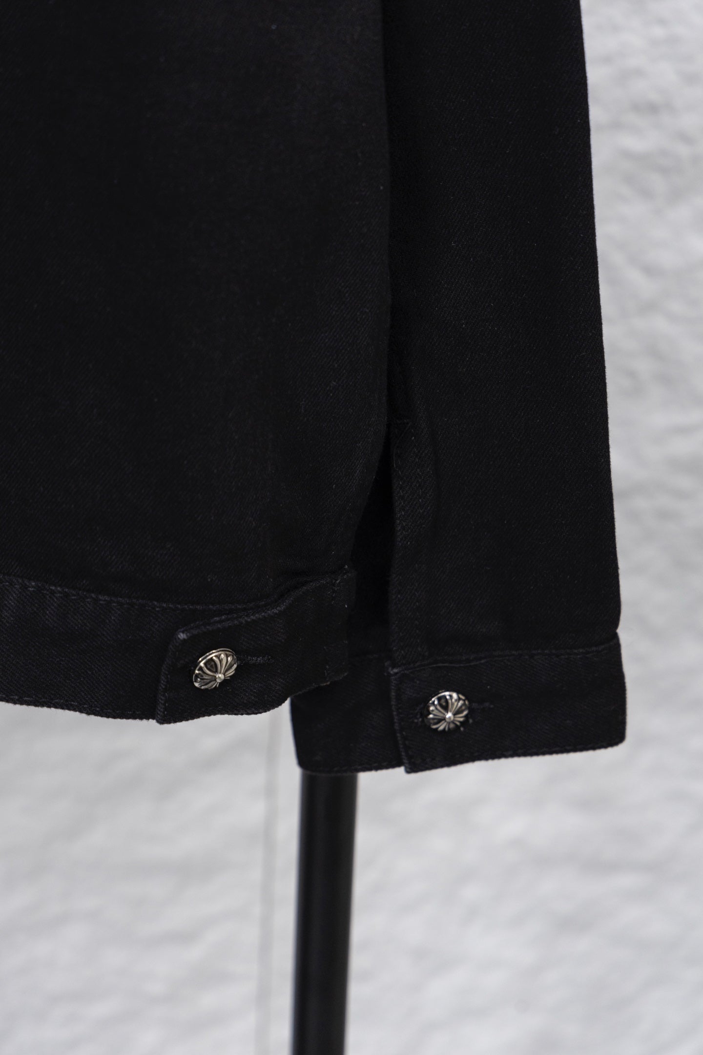 Black denim shirt sleeve cuff with round emblem snap button