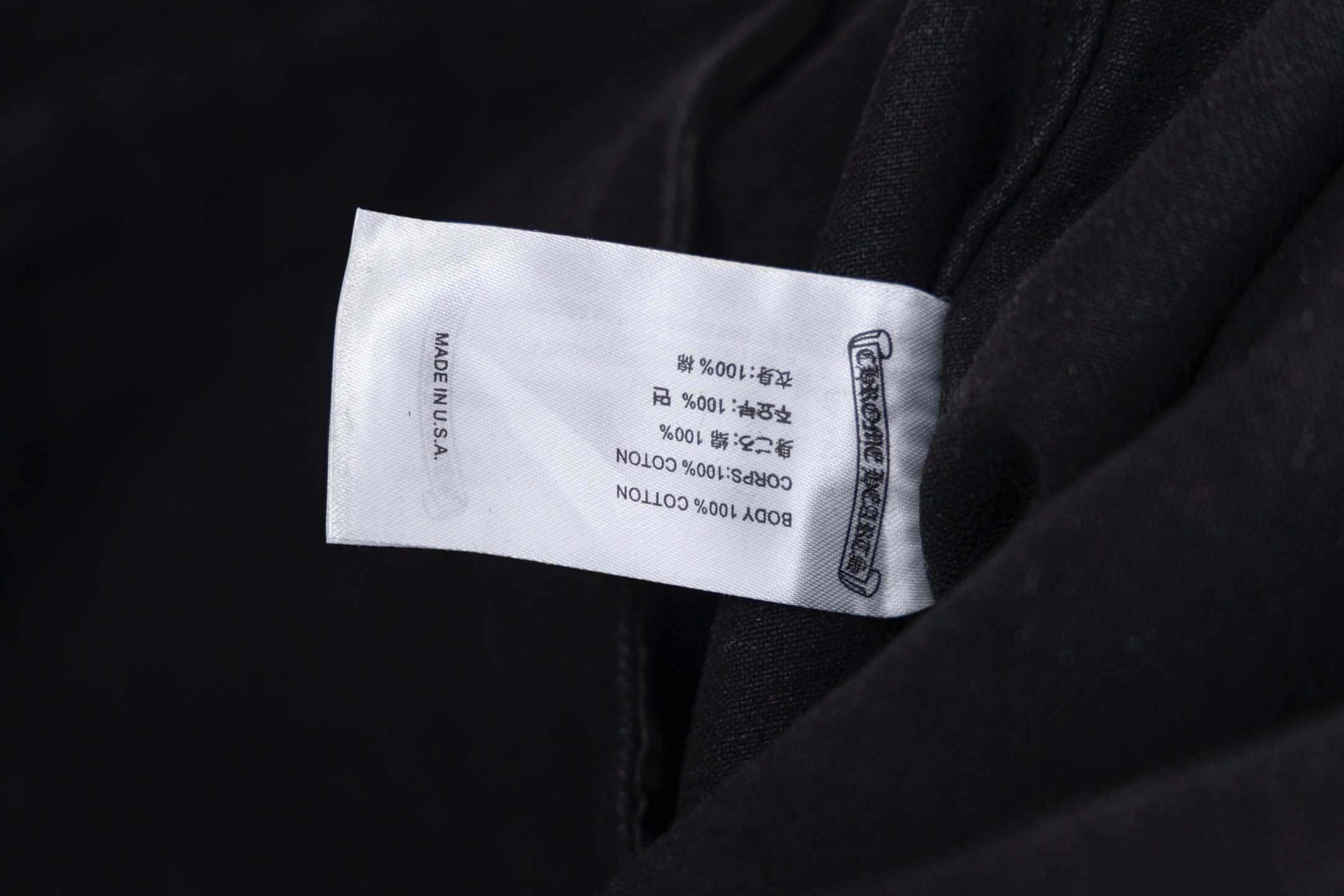 Black garment with white size label on inside seam