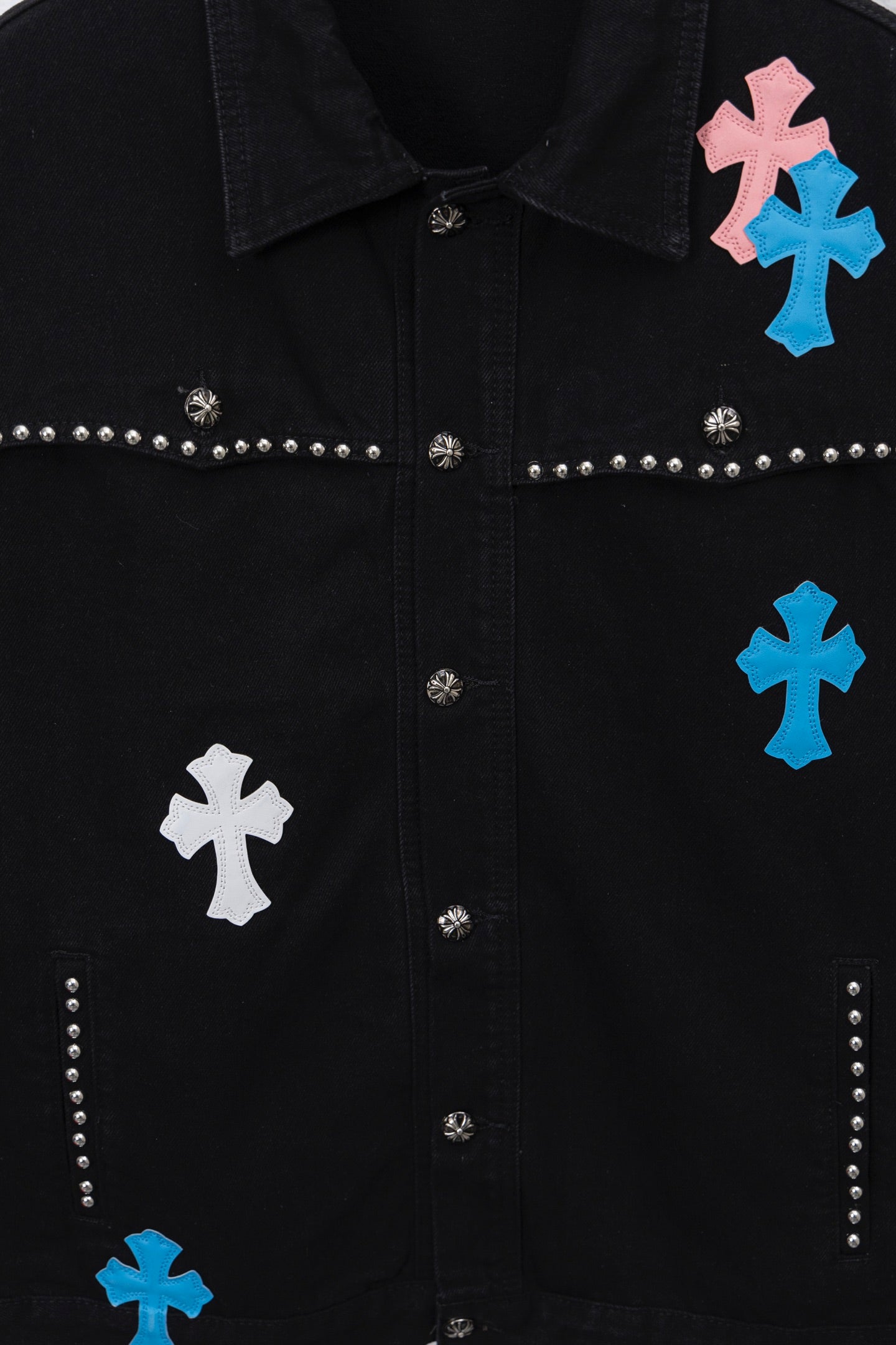 Black studded jacket front with button placket and colorful cross patches
