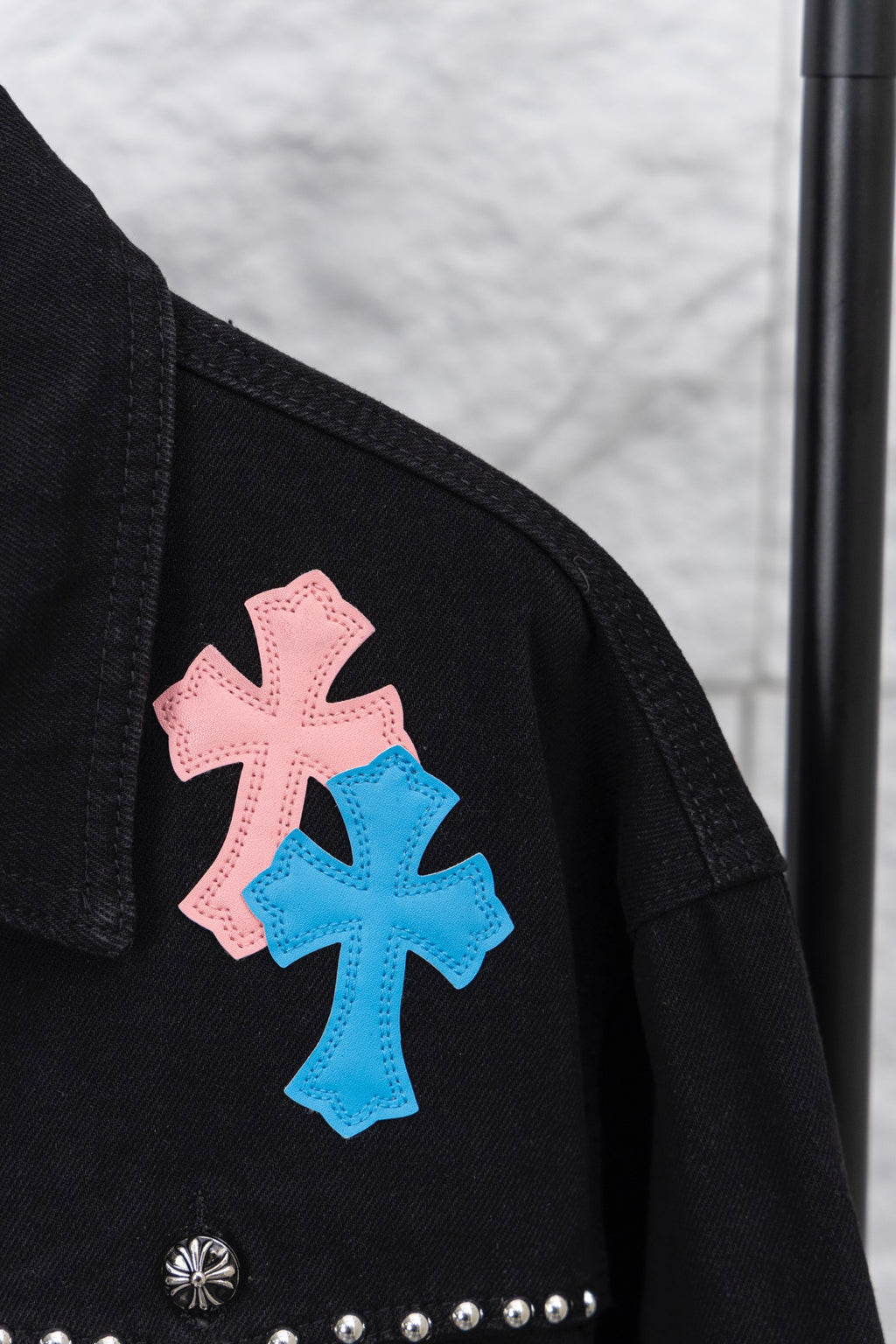Black short sleeve shoulder area with pink and blue cross patch