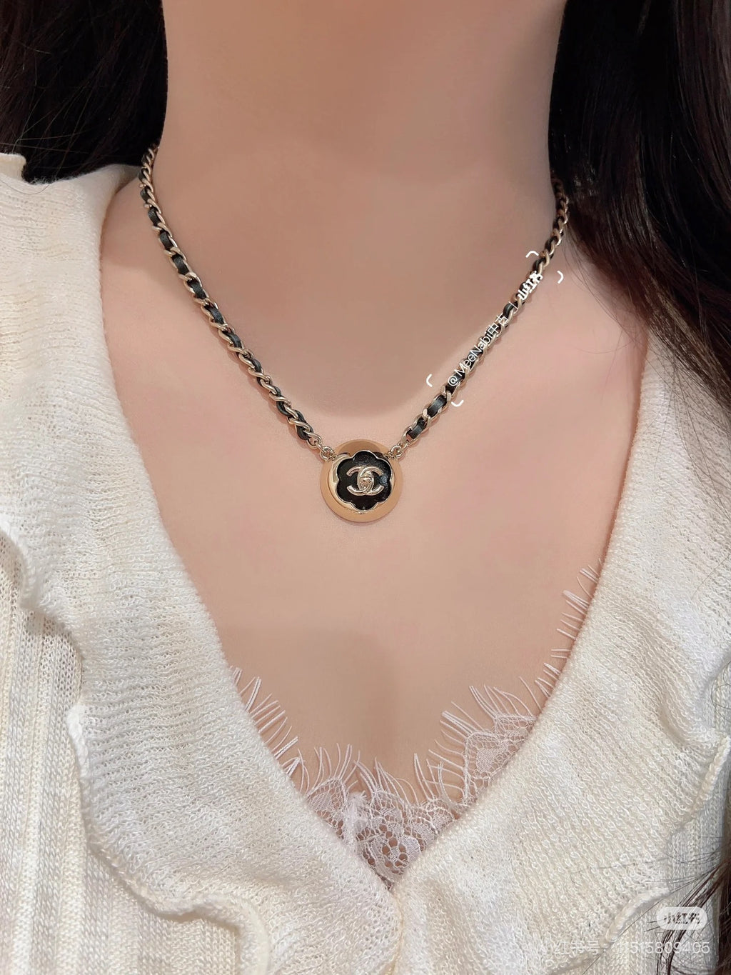 Gold chain necklace with round CC pendant resting at the collarbone