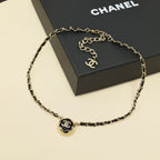 Gold chain necklace with round CC pendant charm centered on the chain