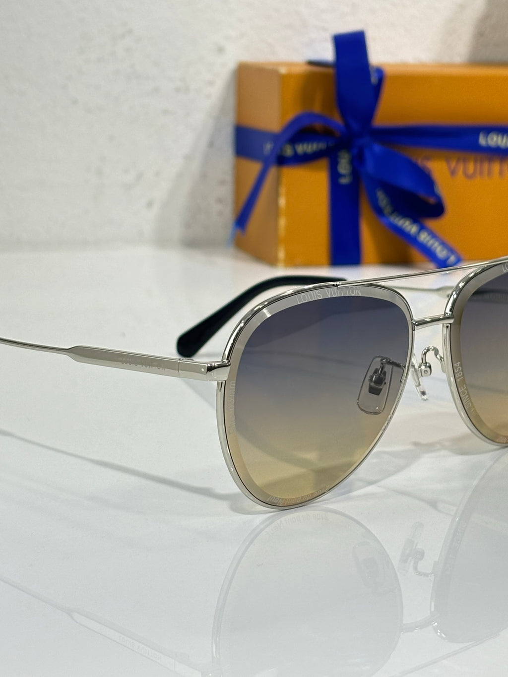 Sunglasses in silver with dark gradient lens and black nose pad, side view.