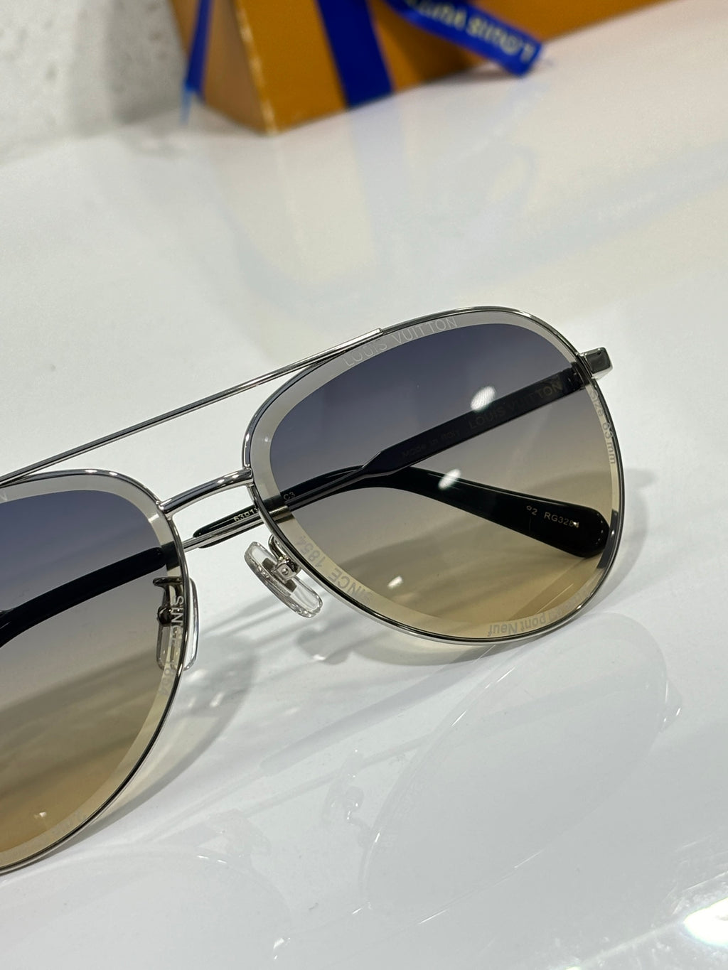 Sunglasses with silver rim and dark gradient lens, close side view.