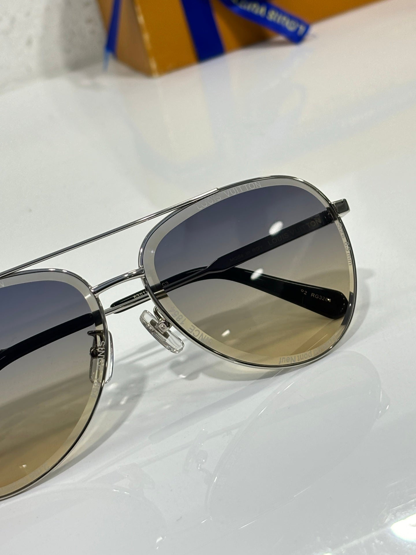 Sunglasses with silver rim and dark gradient lens, close side view.