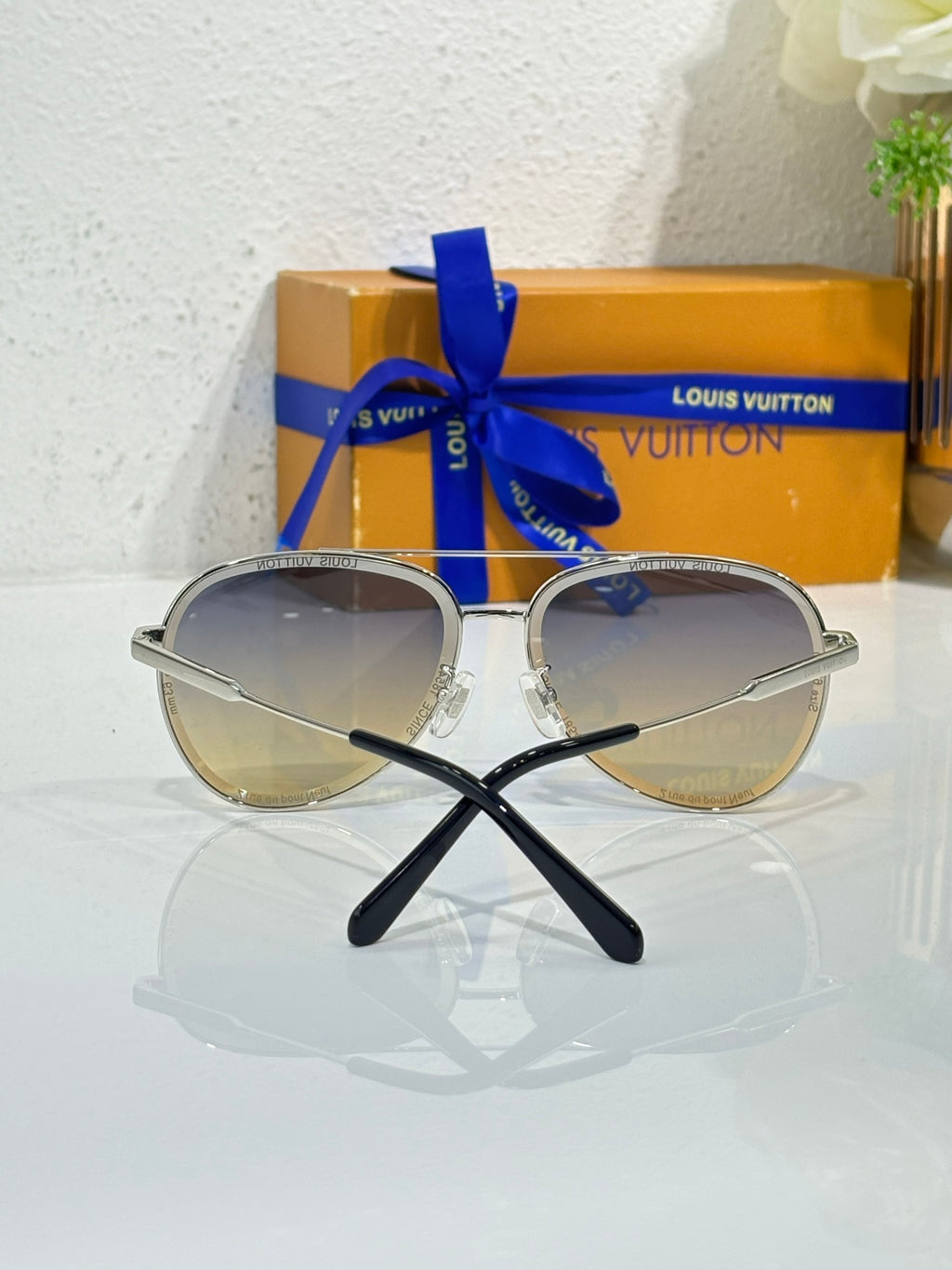 Sunglasses with silver frames and dark gradient lenses, view from front with bridge detail.
