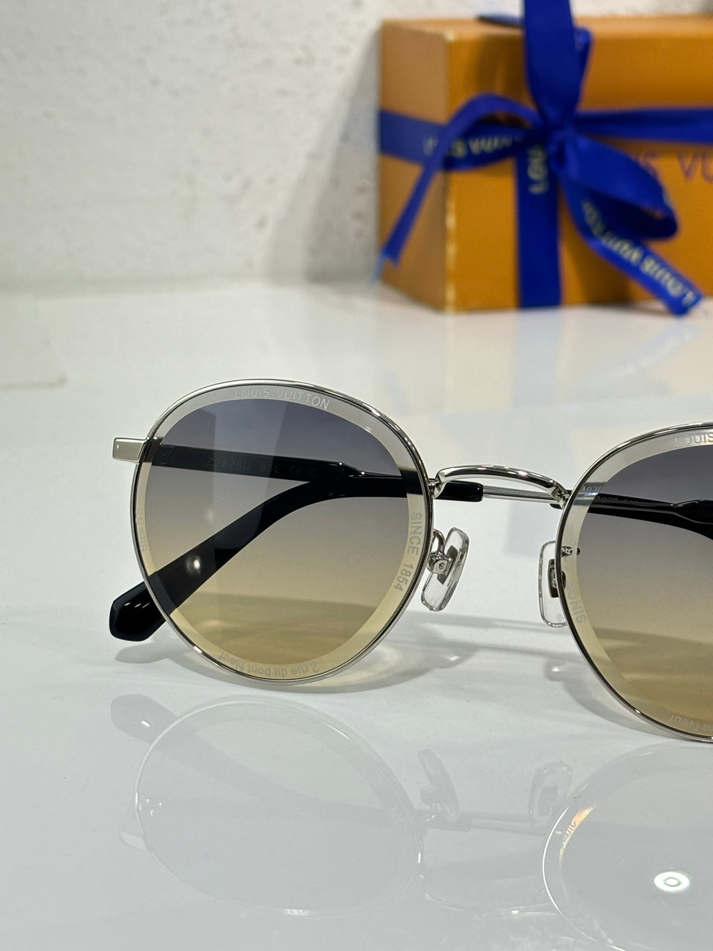 Louis Vuitton round sunglasses, silver metal frame, dark lenses close view