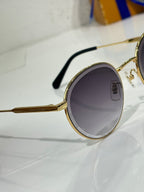 Gold-tone round sunglasses with dark lens and black temple arm detail