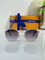 Gold-tone round sunglasses with dark gradient lenses and metal bridge detail