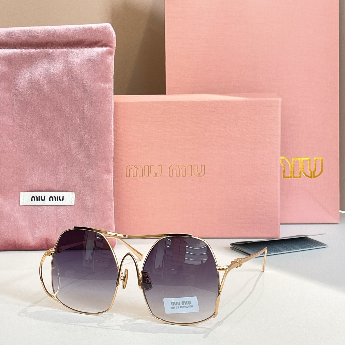 MiuMiu gold-tone sunglasses with dark navy tinted round lenses