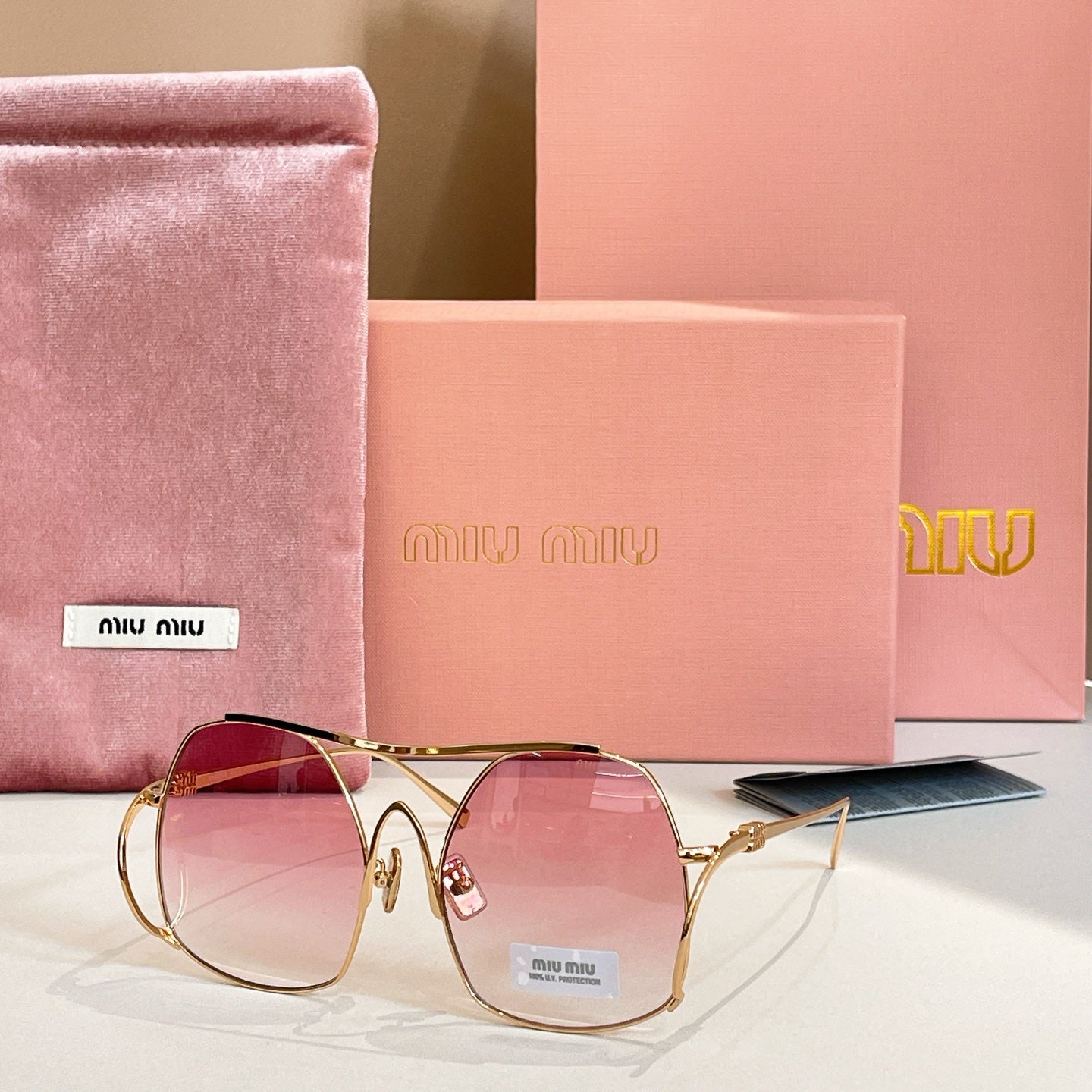MiuMiu gold-tone sunglasses with pink tinted round lenses